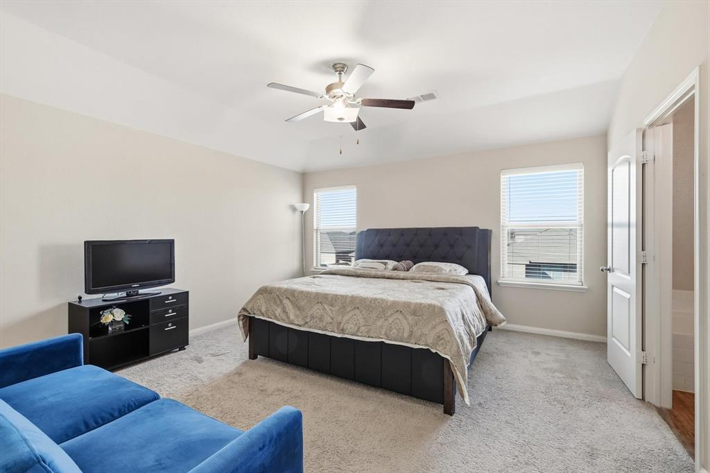 227 Curt Street Anna, TX 75409 - Photo 17 of 40 a spacious bedroom with a bed and a flat screen tv