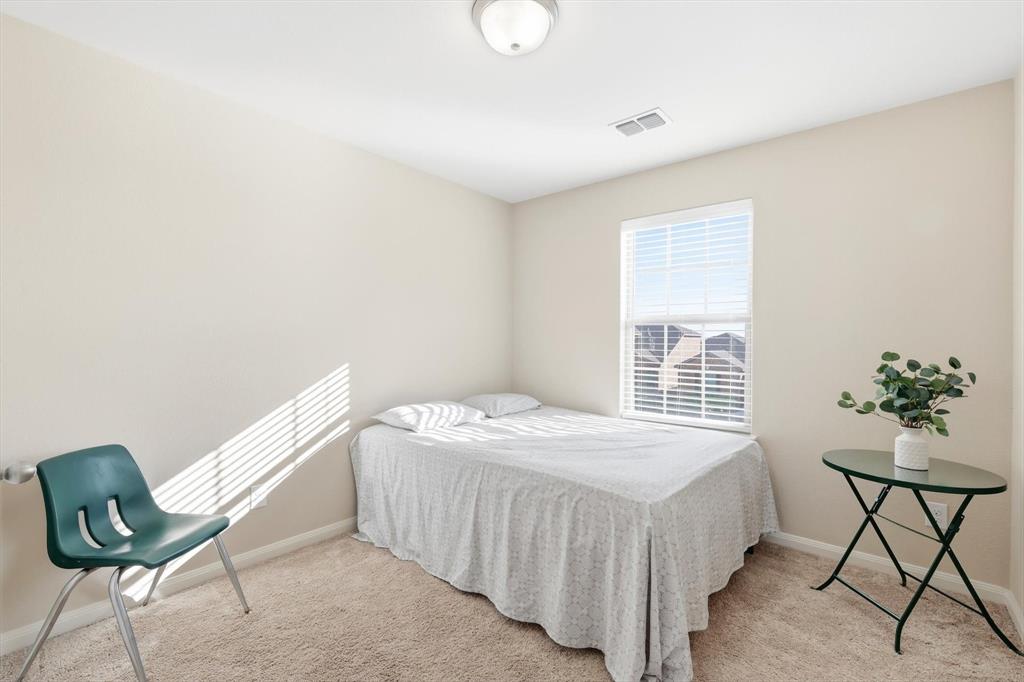 227 Curt Street Anna, TX 75409 - Photo 28 of 40 a bedroom with a bed and a chair