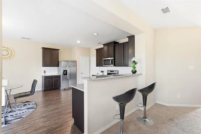 a kitchen with stainless steel appliances a refrigerator and a stove top oven