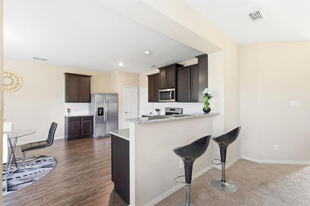 227 Curt Street Anna, TX 75409 - Photo 9 of 40 a kitchen with stainless steel appliances a refrigerator and a stove top oven