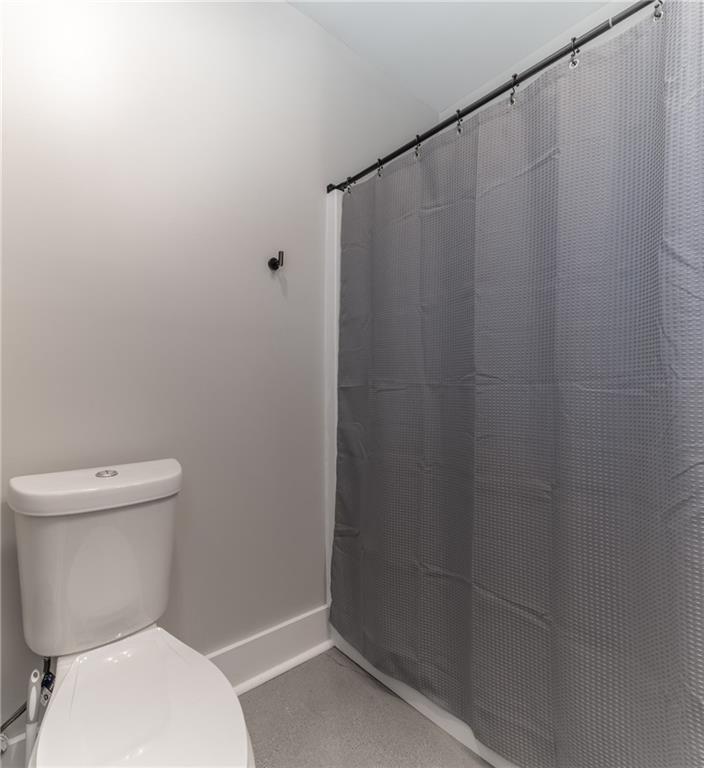 2250 Sperin Road Ball Ground, GA 30107 - Photo 34 of 56 a white toilet sitting next to a shower curtain