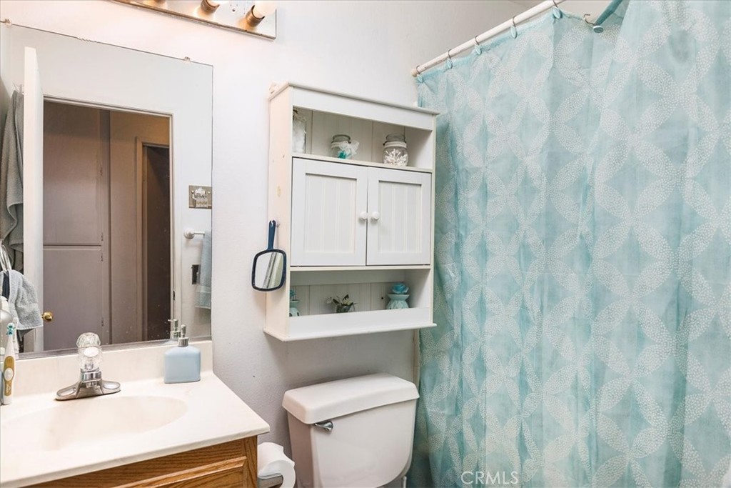 162 Peppertree Way San Jacinto, CA 92583 - Photo 12 of 23 a bathroom with a toilet a sink and mirror