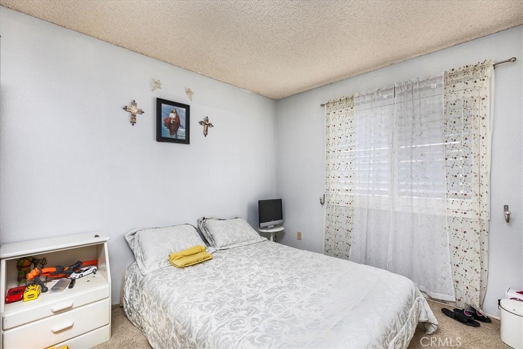 162 Peppertree Way San Jacinto, CA 92583 - Photo 10 of 23 a bedroom with a bed and a painting on the wall