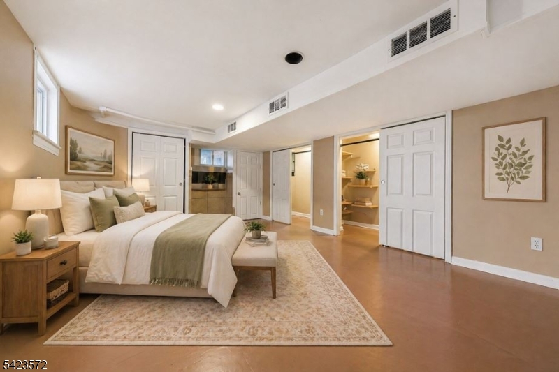 569 Chestnut Street Orange, NJ 07050 - Photo 4 of 9 a spacious bedroom with a bed a table and painting on the wall