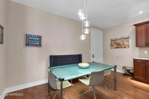 a view of a hallway with wooden floor and a living room