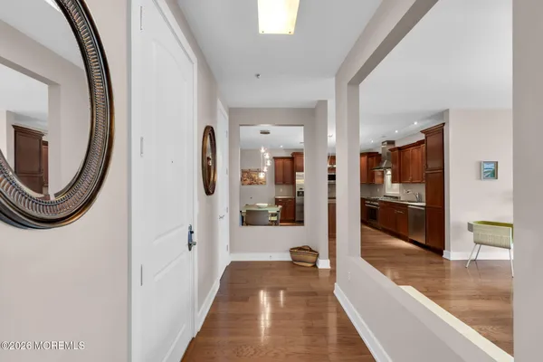 a kitchen with stainless steel appliances granite countertop a stove a refrigerator a kitchen island a dining table and chairs with wooden floor