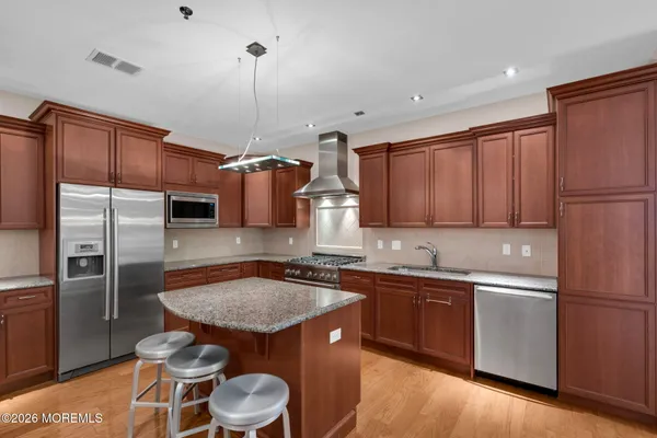 a living room with furniture a large window and wooden floor