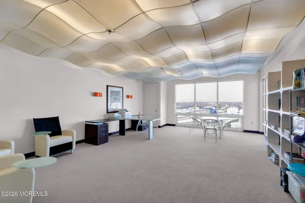a living room with furniture large windows and flat screen tv