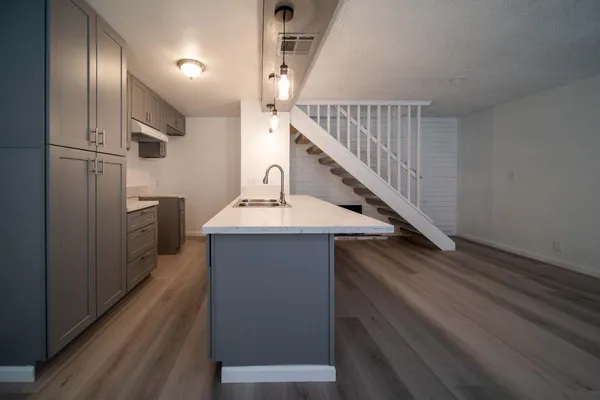 a kitchen with kitchen island wooden floor and electronic appliances