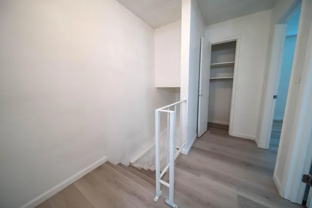 a view of a hallway with wooden floor and entryway