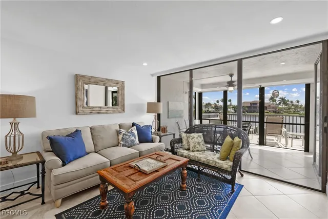 a living room with furniture a chandelier and a large window