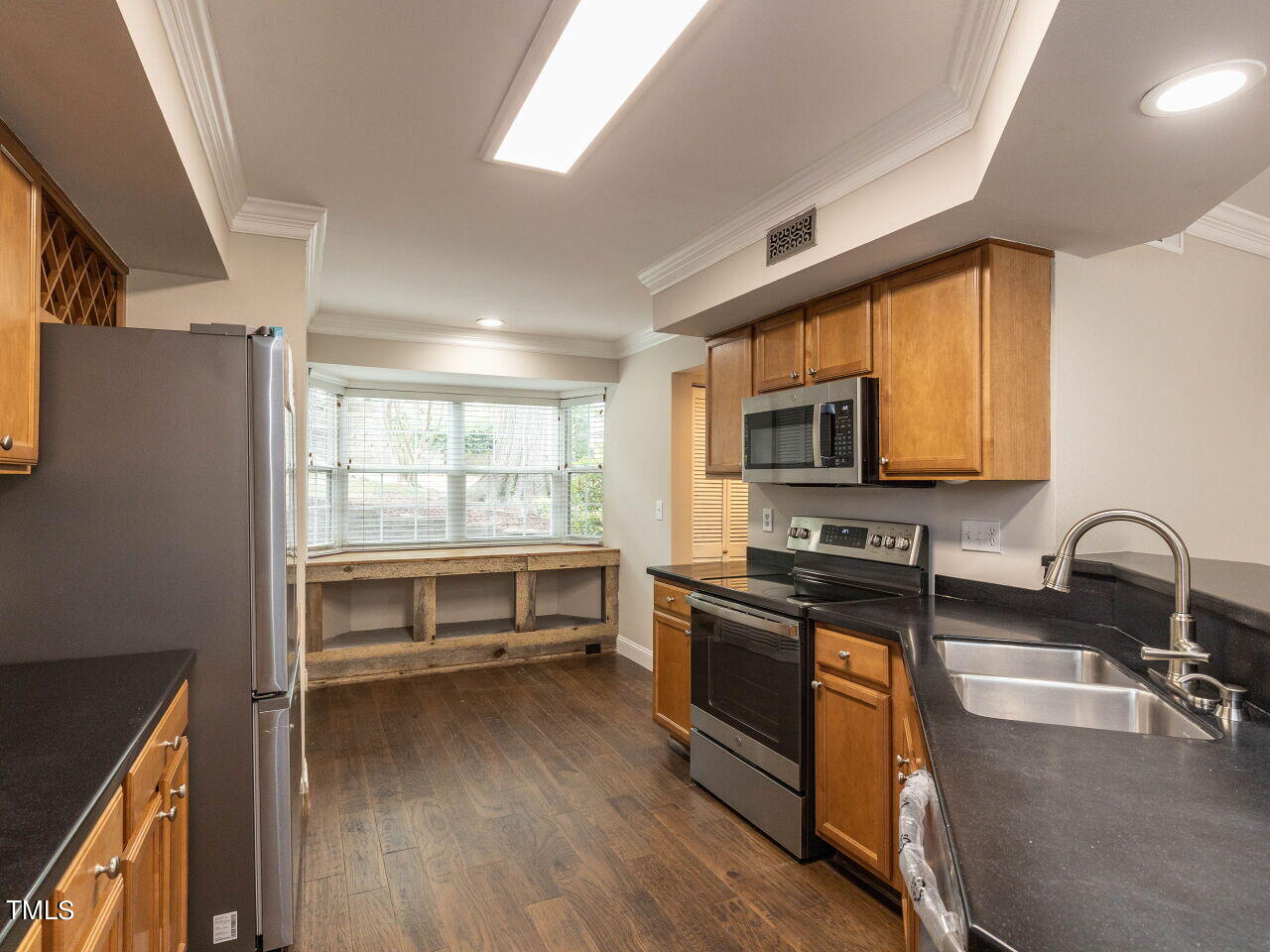 7833 Falcon Rest Circle Raleigh, NC 27615 - Photo 7 of 26 a kitchen with granite countertop a stove a sink and a microwave