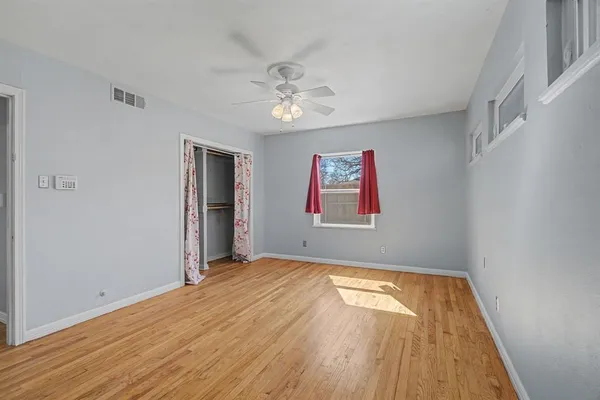 a view of empty room with wooden floor
