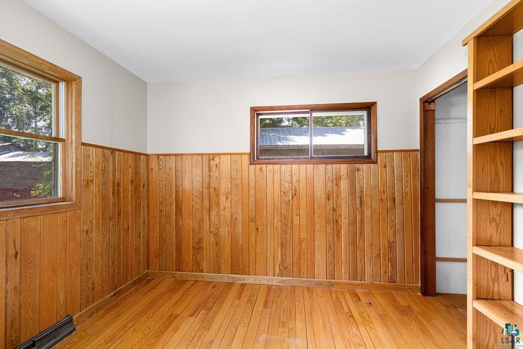 2592 Strandberg Road Barnum, MN 55707 - Photo 42 of 44 Room featuring wood-finish flooring, natural wood paneling, and two windows with wood trim