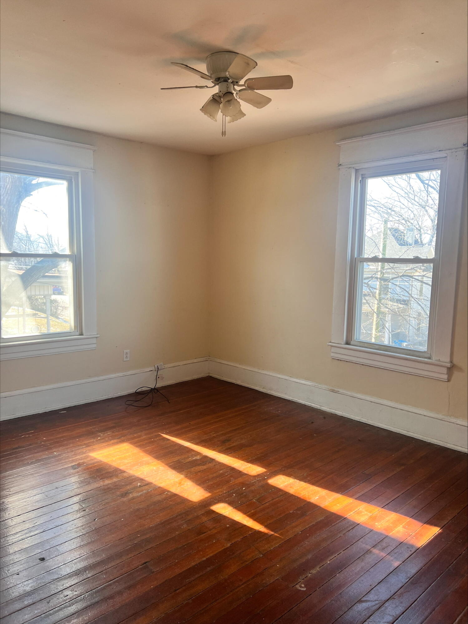 906 5th Street Southeast Roanoke, VA 24013 - Photo 4 of 11 an empty room with wooden floor chandelier fan and windows