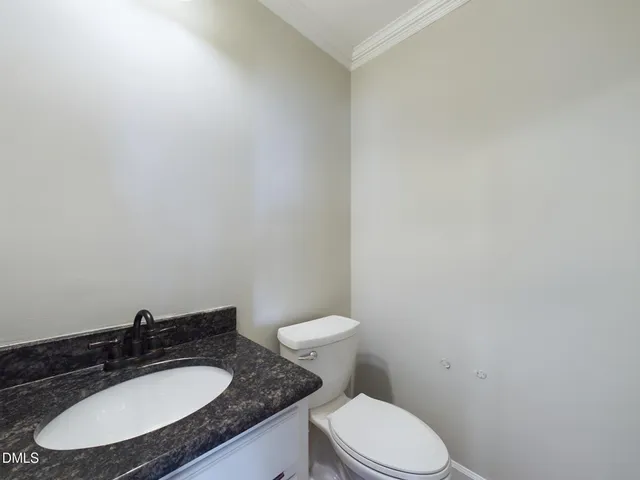 a kitchen with granite countertop a stove and white cabinets