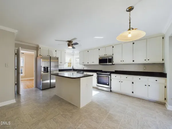 a kitchen with granite countertop a sink counter top space appliances and cabinets