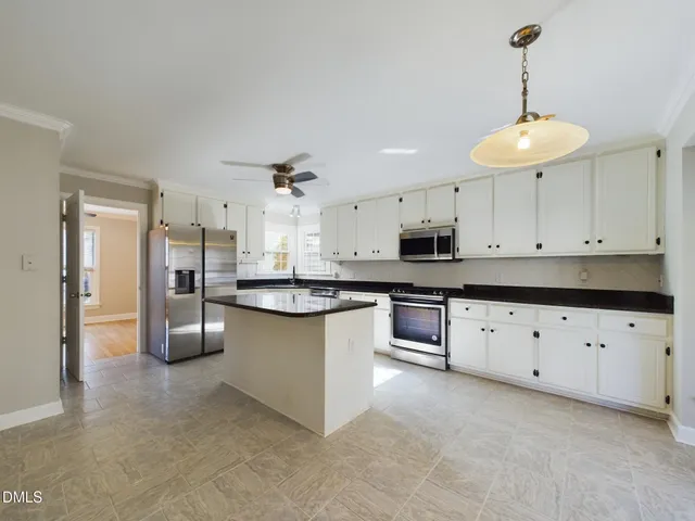a kitchen with granite countertop a sink counter top space appliances and cabinets