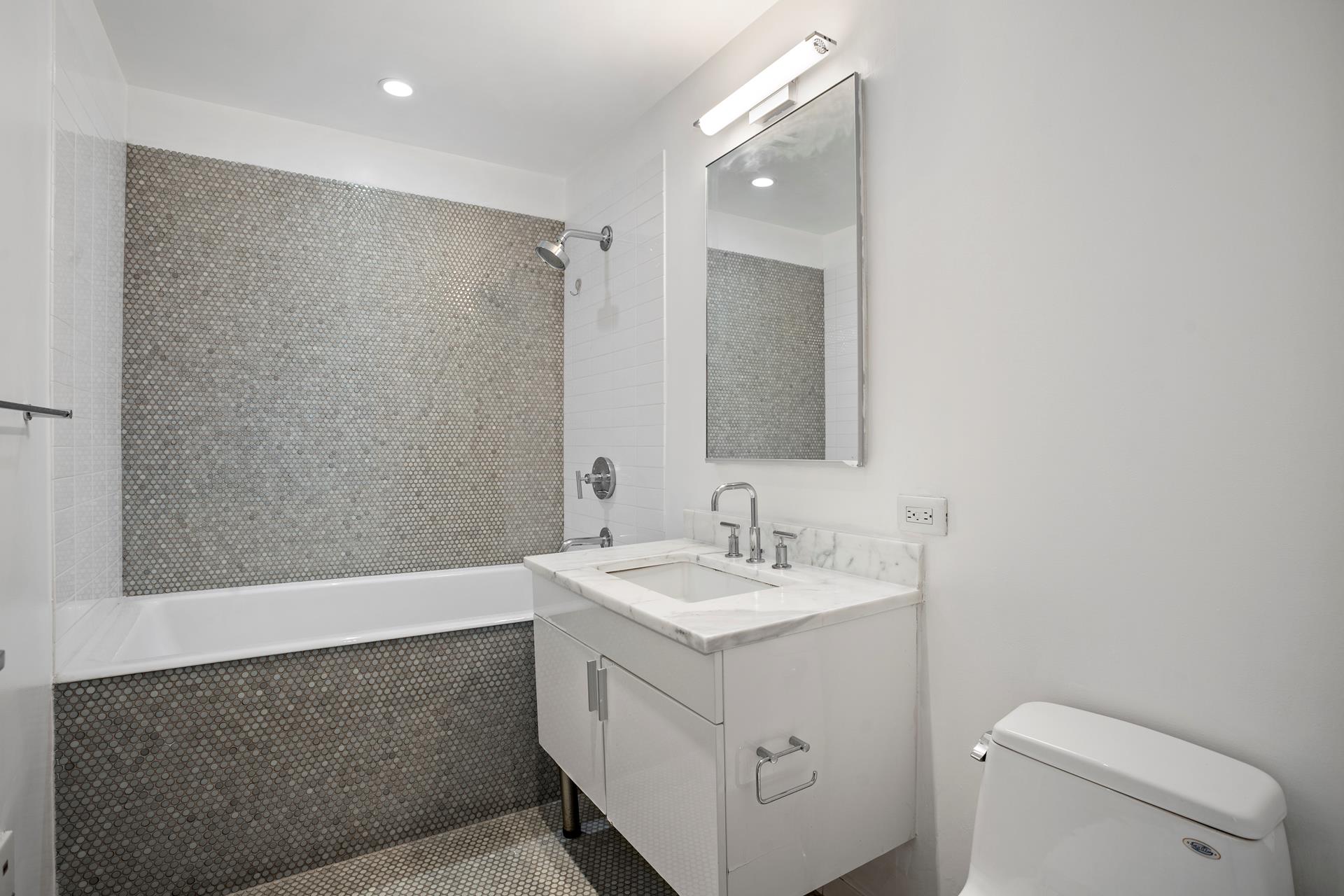 300 East 79th Street, Unit 5C Manhattan, NY 10075 - Photo 7 of 12 a bathroom with a sink a toilet and a mirror