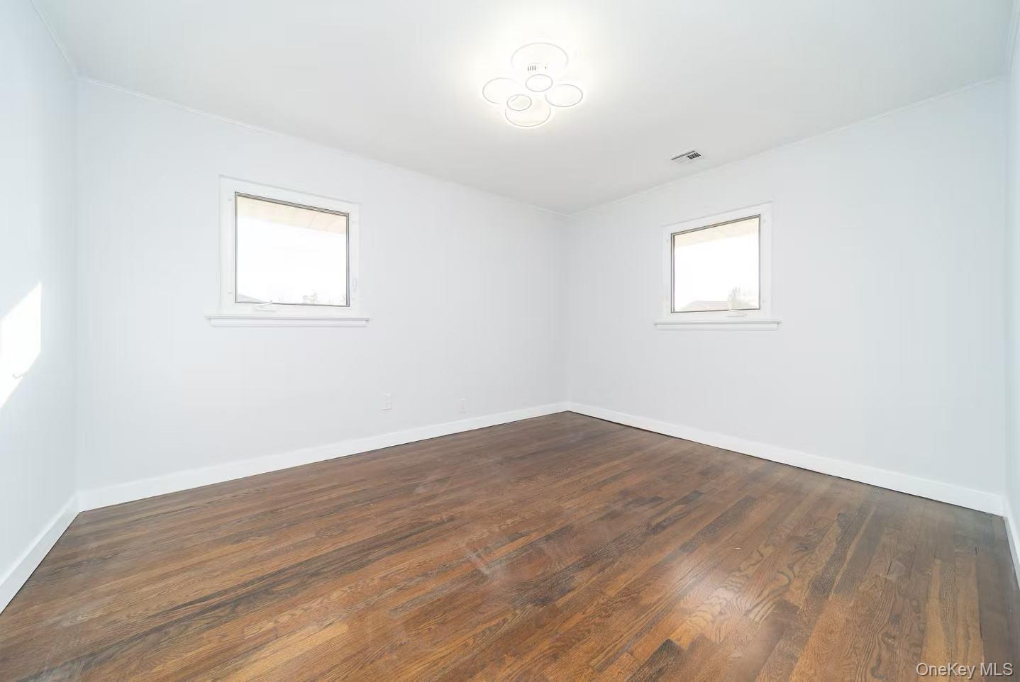 8 Spector Lane Plainview, NY 11803 - Photo 9 of 15 a view of empty room with wooden floor and fan