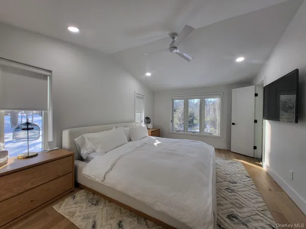 a spacious bedroom with a large bed and a flat screen tv