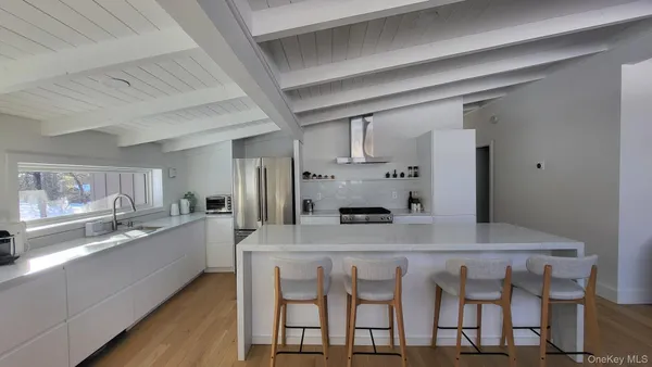 a kitchen with granite countertop a table chairs stove and refrigerator