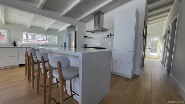 a kitchen with stainless steel appliances kitchen island a refrigerator and wooden floor