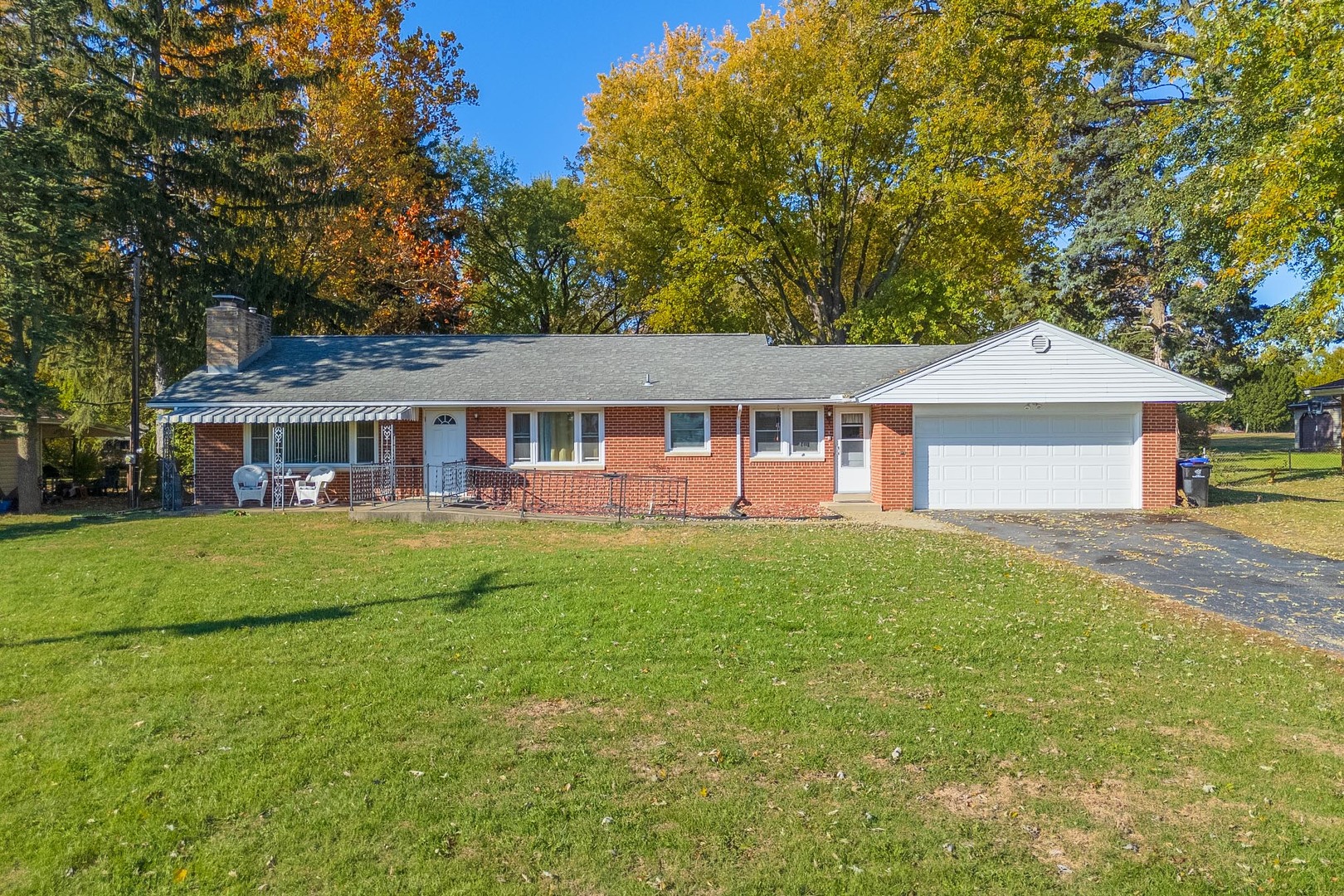 a front view of a house with yard patio and green space