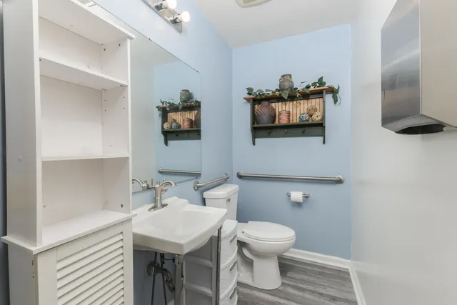 a bathroom with a toilet a sink and mirror