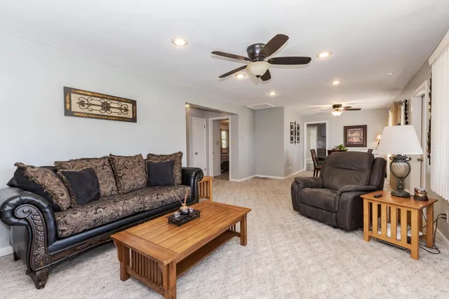 a living room with furniture and a view of kitchen