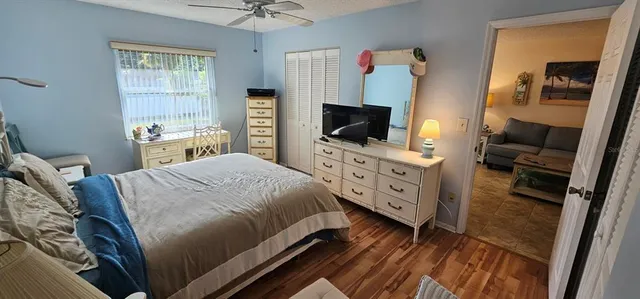 a bedroom with a bed and flat tv screen on the dresser