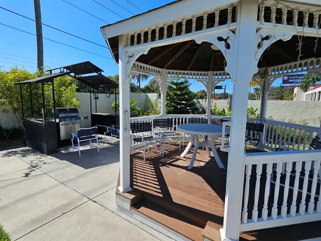 a view of a patio with couches table and chairs under an umbrella