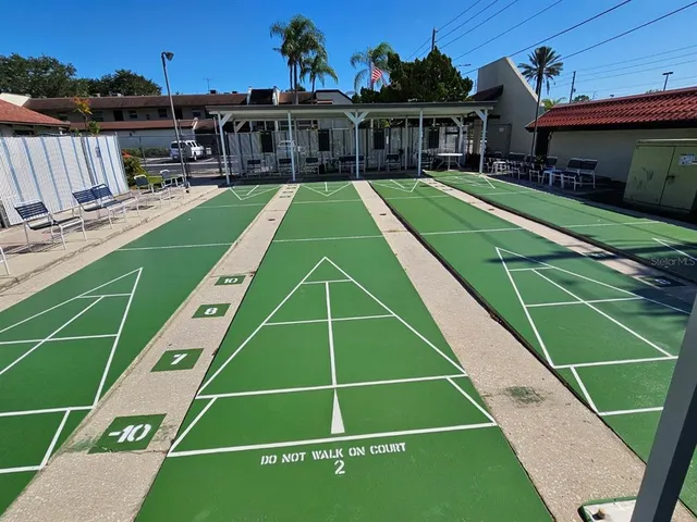 a view of a tennis ground with large windows and couches chairs