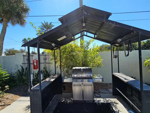 a patio with a table and chairs under an umbrella