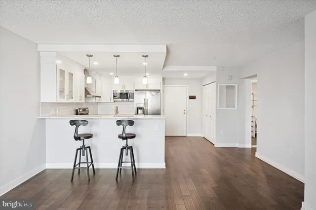 a kitchen with stainless steel appliances kitchen island hardwood floor and a sink