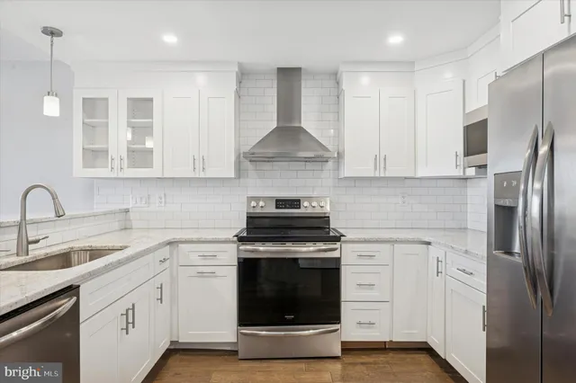 a kitchen with stainless steel appliances granite countertop a stove a refrigerator and a sink