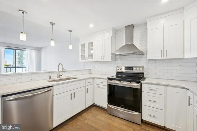 a kitchen with stainless steel appliances granite countertop a sink stove and cabinets