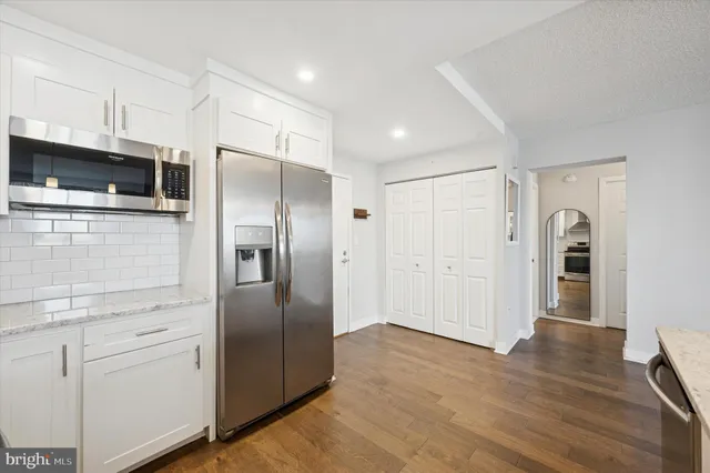 a metallic refrigerator freezer sitting in a kitchen
