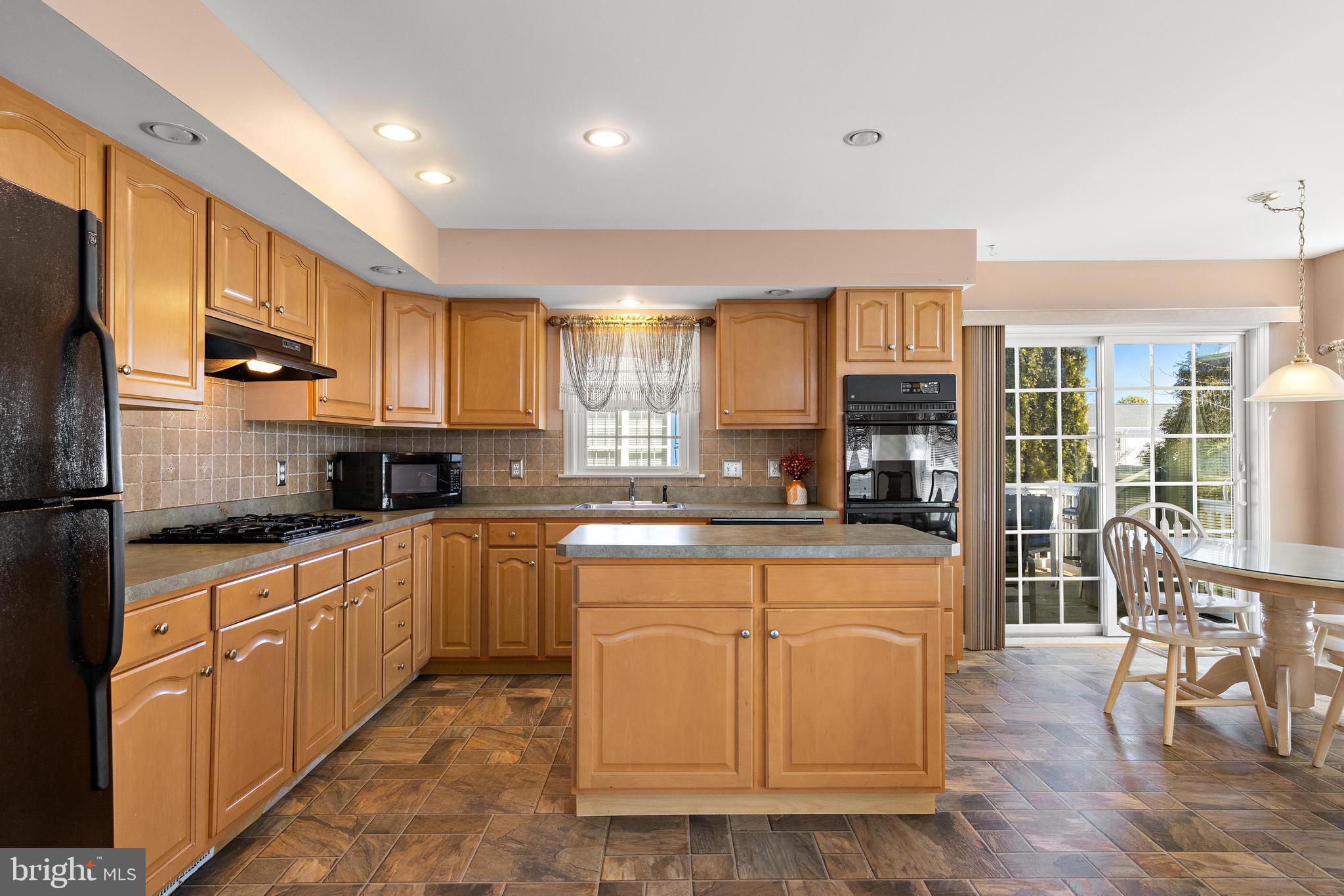 75 Oak Ridge Lane Manahawkin, NJ 08050 - Photo 10 of 50 a kitchen with stainless steel appliances granite countertop a stove top oven a sink dishwasher a refrigerator and cabinets with wooden floor