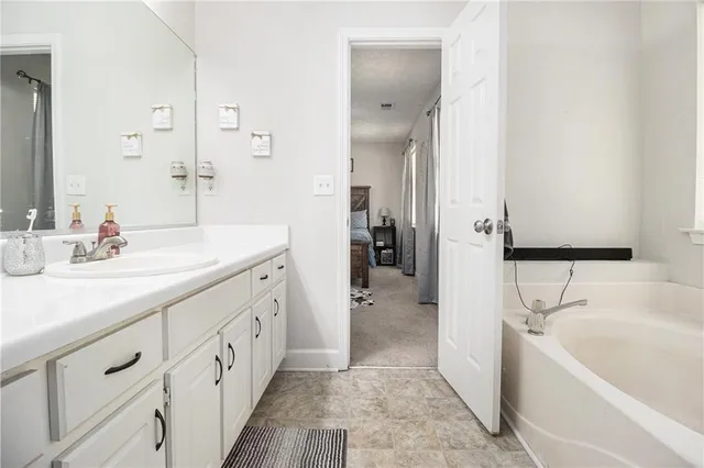 a spacious bathroom with double vanity a mirror a bathtub and shower