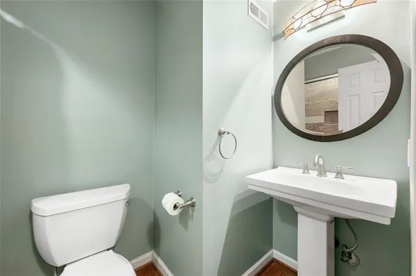a bathroom with a toilet sink and mirror