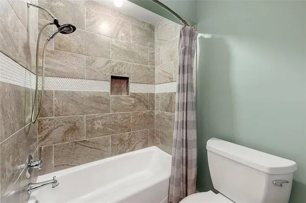 a bathroom with a toilet and bathtub