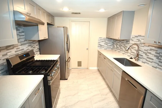 a kitchen with a sink stove and refrigerator