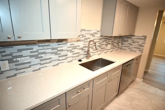a kitchen with a sink and a stove top oven