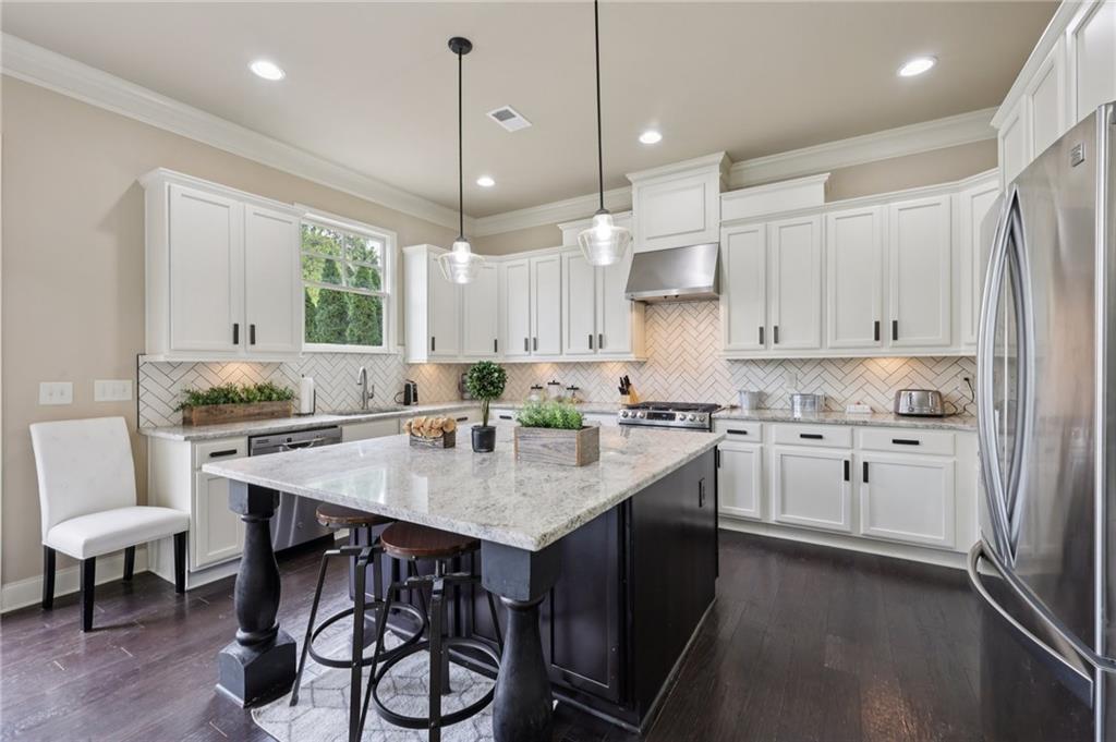 1710 Bramble Bush Way Suwanee, GA 30024 - Photo 12 of 40 a kitchen with kitchen island granite countertop a sink cabinets and stainless steel appliances