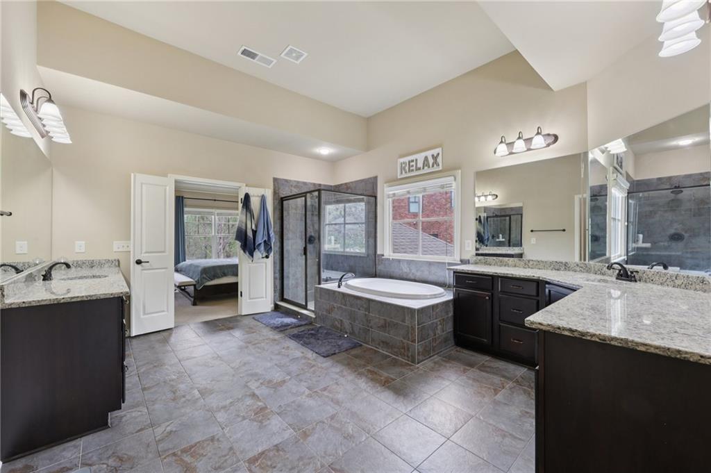 1710 Bramble Bush Way Suwanee, GA 30024 - Photo 20 of 40 a large spacious bathroom with a granite countertop tub sink and mirror