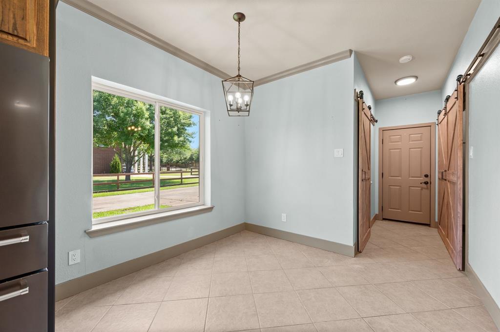 508 Chandler Road Keller, TX 76248 - Photo 13 of 39 Additional dining space with beautiful windows and farmhouse lighting. Barn doors open to laundry room and pantry. Exit door leads to garage.