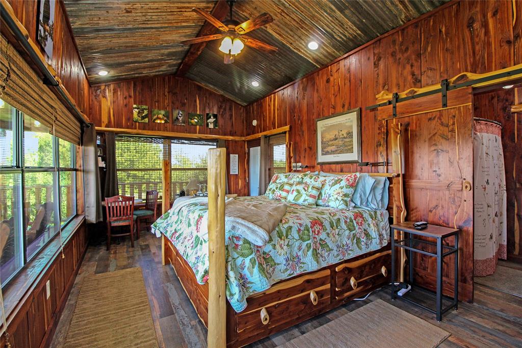 7304 Shady Lane Scurry, TX 75158 - Photo 26 of 40 Bedroom with wood walls, a barn door, dark wood-style floors, and wood ceiling