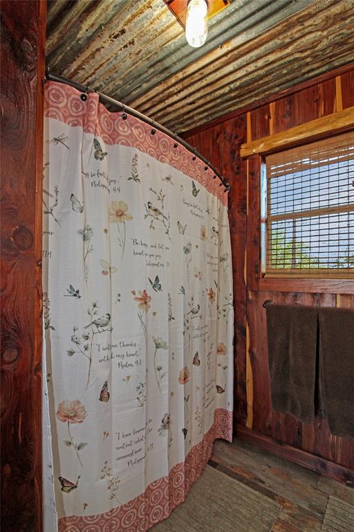 7304 Shady Lane Scurry, TX 75158 - Photo 30 of 40 Full bathroom featuring wood walls, a shower with curtain, and wood finished floors