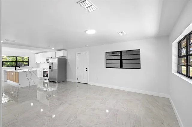 an empty room with wooden cabinet and windows